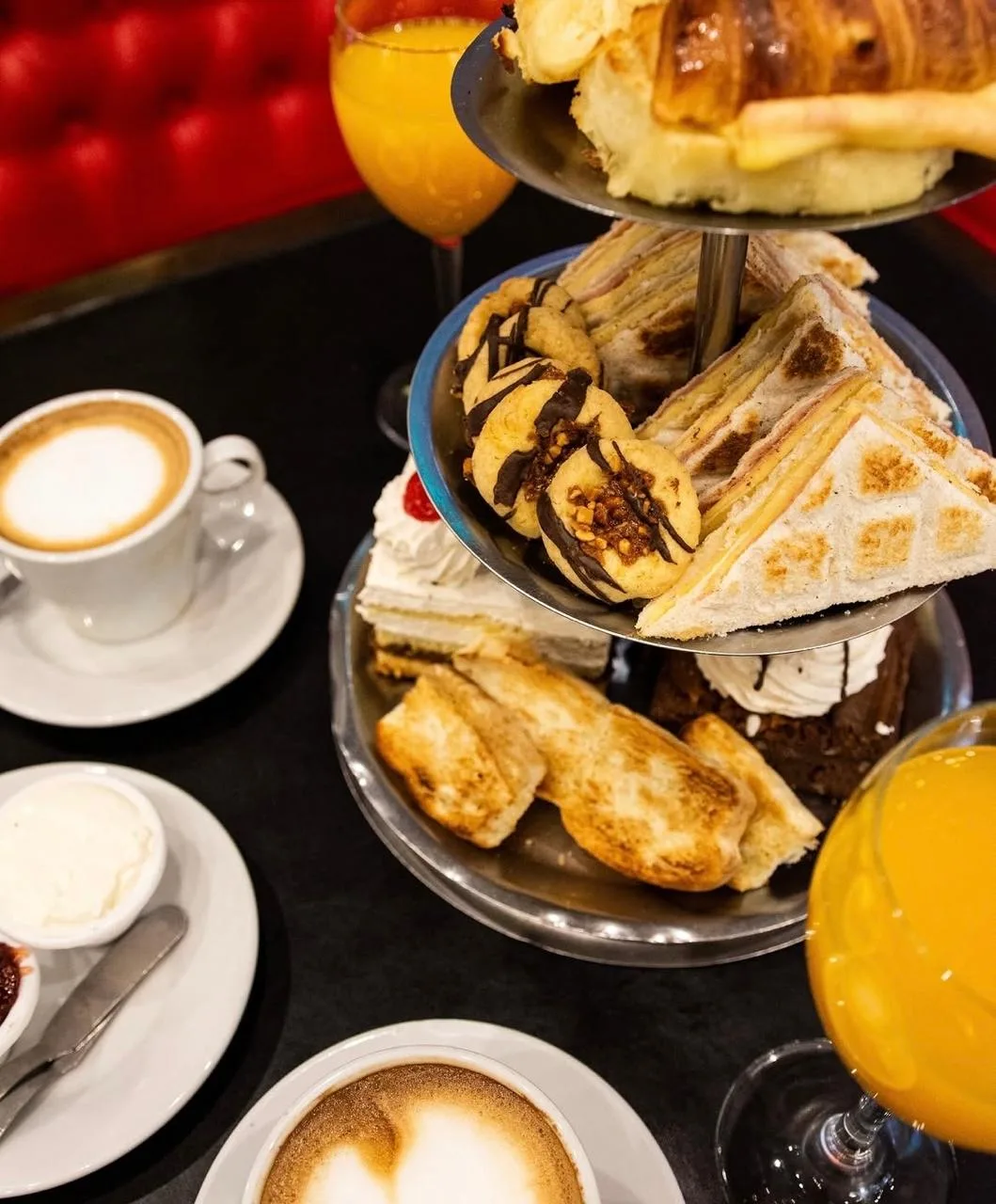 Torre de dulces, tostados y masas con café con leche y jugo de naranja
